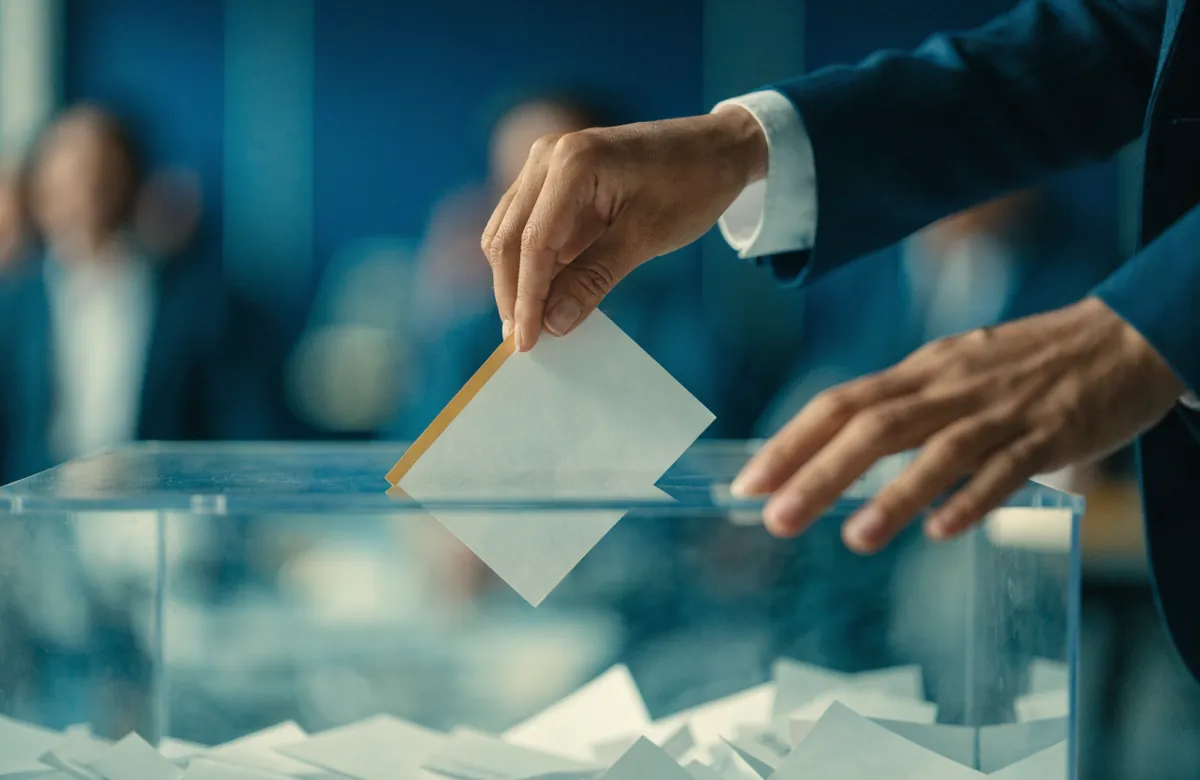 Asociado depositando su voto en una urna transparente